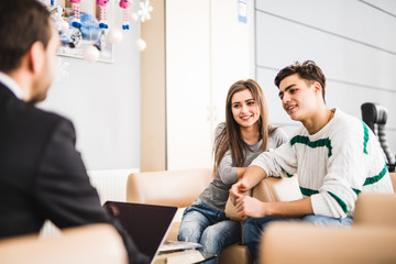 Obraz premium happy couple speak with dealer buying car in auto show or salon