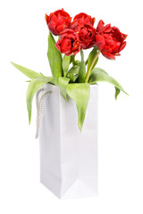 Red tulips in silver paper bag