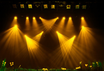 The yellow light from the spotlights through the smoke at the theater during the performance. Lighting equipment. - obrazy, fototapety, plakaty
