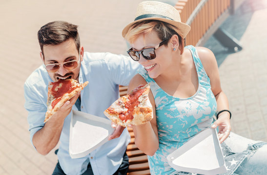 Couple eating pizza outdoors. Dating, relationships, food, lifestyle concept