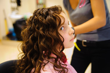 Fototapeta premium The little girl doing a hairdress