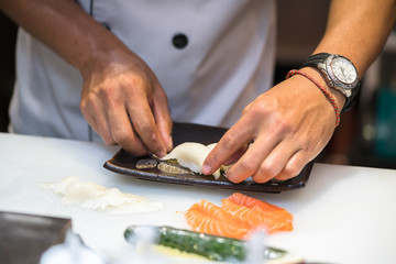 Obraz na płótnie Canvas chef making sushi in the kitchen