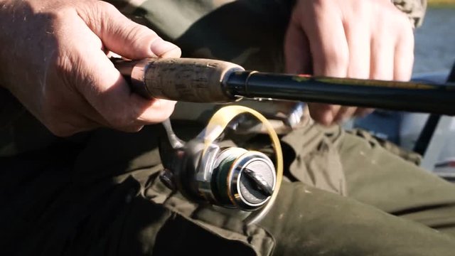 Close-up of male hands holding a fishing rod while catching fish. HD