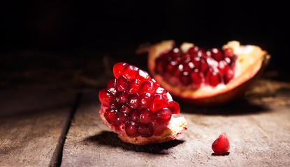 Fresh peeled pomegranates with ruby red beans on old wooden table
