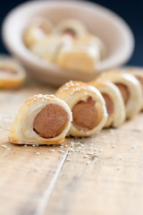  Sausages rolled in croissant dough baked cooling on metal rack.