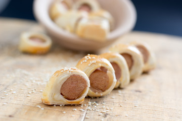  Sausages rolled in croissant dough baked cooling on metal rack.