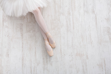 Ballerina in pointe shoes, graceful legs, ballet background