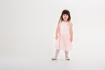 beautiful little girl in pink Princess dress on a gray backgroun
