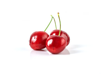 Three fresh ripe cherries isolated on white background
