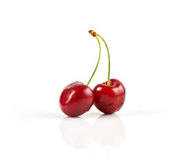 Two fresh ripe cherries isolated on white background