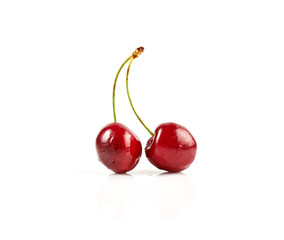 Two fresh ripe cherries isolated on white background