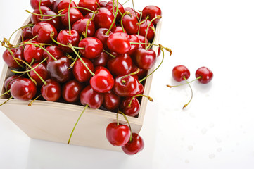 Obraz na płótnie Canvas Ripe cherry in wooden box isolated on white background