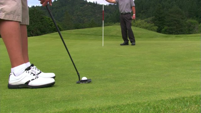 Golfer making a long putt in two strokes