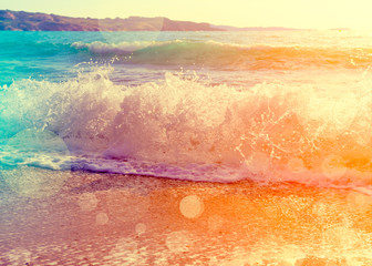 Waves breaking on a beautiful sandy beach on the shore of the mediterranean coast. Vintage stylized...