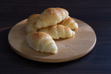 Croissant on chopping board on wooden table /Still life and selective focus image.