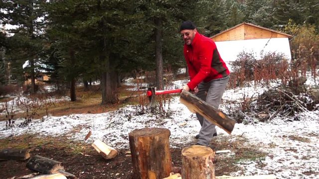 lumberman cutting wood with axe against beautiful Altai nature 
