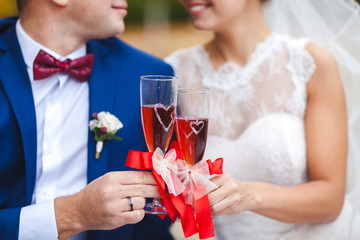 Womans and mans wedding hands with glasses red wine