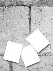 Three blank square frames on gray stone tile pavement background