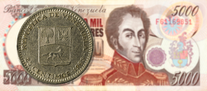 25 centimos coin against 5000 venezuelan bolivar bank note (brown) obverse