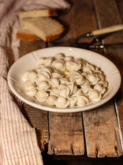  Dumplings (ravioli) in a plate on a wooden surface