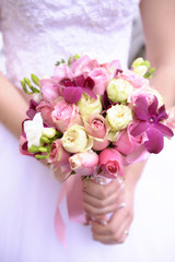 Bride holding a wedding flower arrangement with violet and purple hues