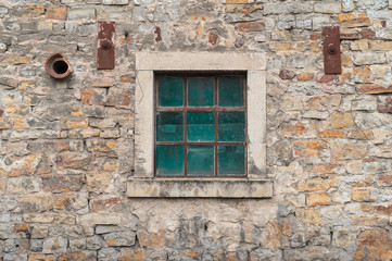 Fototapeta na wymiar Old window on a stone wall