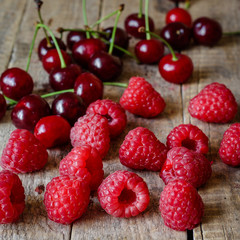 Berries of raspberries and cherries on a wooden surface