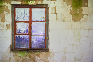 Stare kolorowe okno na starej białej ścianie