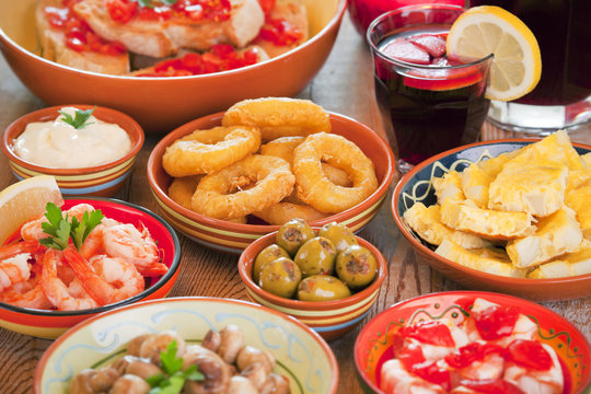 Assortment of Spanish tapas and sangria on a rustic table