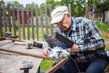 Senior man welding metal construction