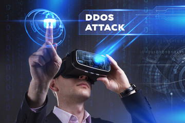 Business, Technology, Internet and network concept. Young businessman working in virtual reality glasses sees the inscription: Ddos attack