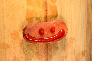 Sausage with ketchup on a wooden table