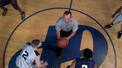 Slow-motion overhead view of basketball players at tipoff - Powered by Adobe