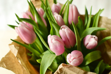 Bouquet of pink tulips in craft brown paper