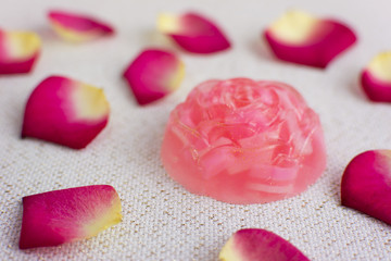 Organic homemade rose soap. Delicate rose petals on the background.