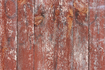 The old, vertical, wooden, frayed, the paint is red in the cracks.