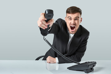 Naklejka premium young man dials the phone number while sitting in the office