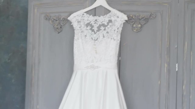 White wedding dress hangs on hangers close-up