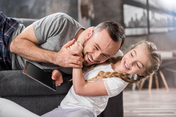 Father and daughter using digital tablet