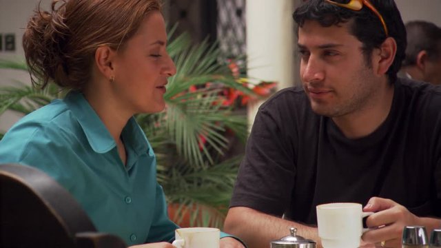 Close view of young couple drinking chocolate and kissing in a restaurant in Cuenca, Ecuador