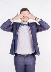 portrait young businessman covering his eyes with his hand. emotions, facial expressions, feelings, body language, signs. image on a white studio background.