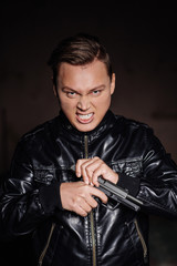 assassin aims his pistol on dark background