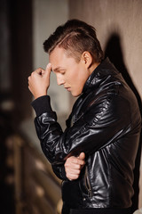 young stressed and suffering man on a dark background.