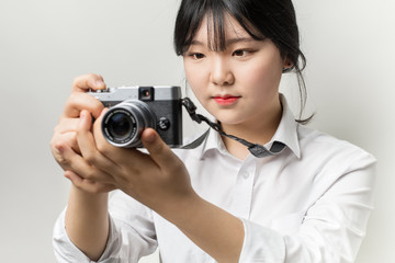 Female hand holding modern camera (mirrorless camera). camera in hand. Focus on people's eyes