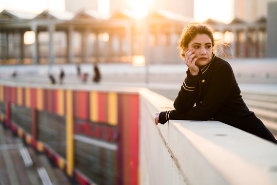 Young thoughtful woman leaning on wall