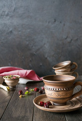 Herbal tea, herbs and flowers in a  clay cup on wooden table