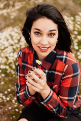 Beautiful woman smelling a daisy