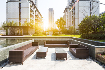 wooden benches in park and modern residential buildings