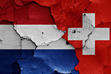 flags of Netherlands and Switzerland painted on cracked wall