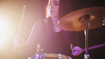 Young woman percussion drummer performing with drums